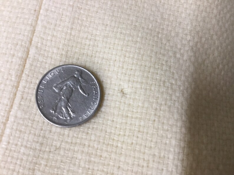 May include: A silver French coin with the words "Republique Francaise" inscribed around the edge.