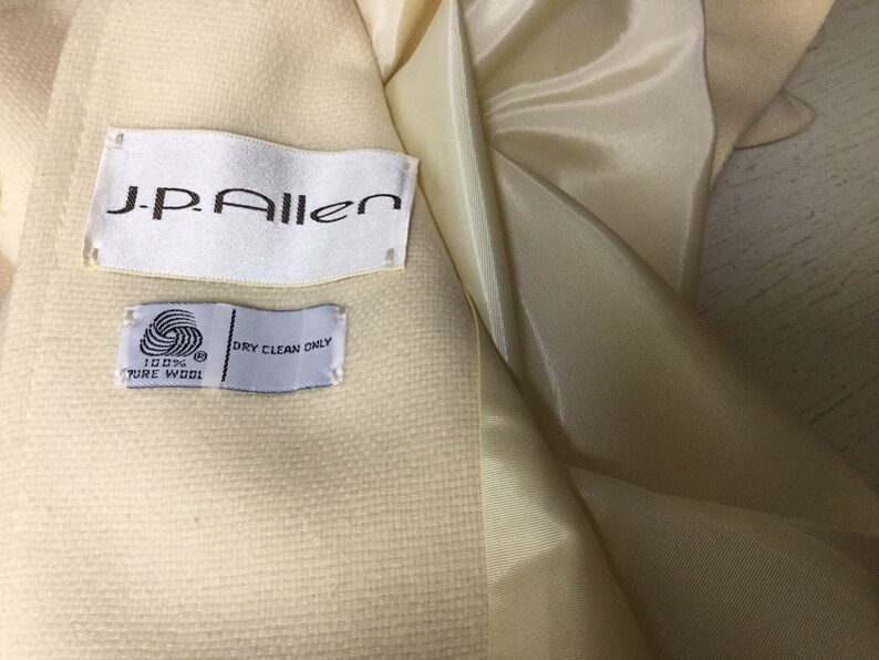 May include: A white wool coat with a J.P. Allen label and a tag that says "100% Pure Wool" and "Dry Clean Only."