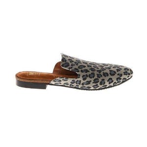 May include: A single, open-back slip-on shoe with a leopard print design. The shoe features a brown leather sole and a gray and black patterned upper. The shoe is designed for casual wear.