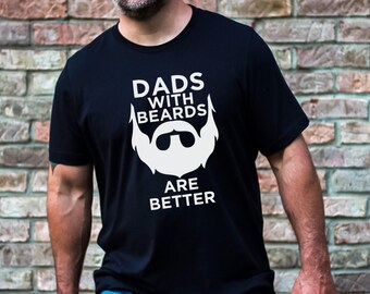 Puede incluir: Camiseta negra con texto blanco que dice "Dads with Beards are Better" y un gráfico blanco de una cara barbuda con gafas de sol.