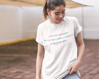 May include: A white t-shirt with the text "store bought neurotransmitters are just fine" in colorful letters.