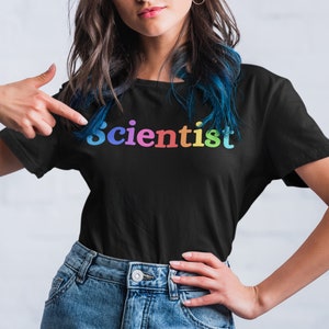 May include: A black t-shirt with a rainbow colored word "Scientist" printed on the front.
