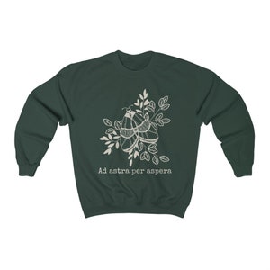 Op de afbeelding: Een donkergroen sweatshirt met een witte omtrek van twee motten op een tak met bladeren. De tekst "Ad astra per aspera" is onder de motten gedrukt.