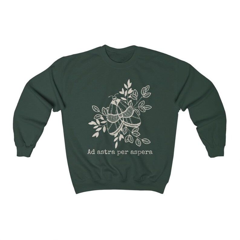 Op de afbeelding: Een donkergroen sweatshirt met een witte omtrek van twee motten op een tak met bladeren. De tekst "Ad astra per aspera" is onder de motten gedrukt.
