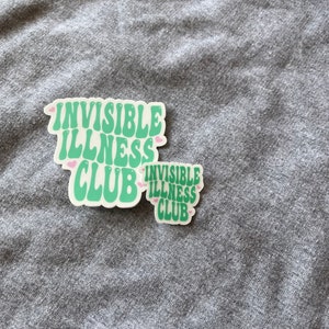 May include: Two green stickers with the text "Invisible Illness Club" in a retro font. The stickers have pink hearts around the text.
