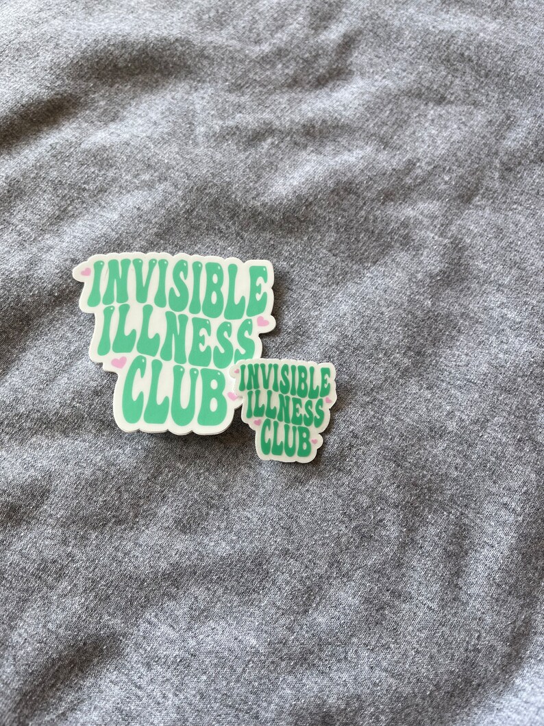May include: Two green stickers with the text "Invisible Illness Club" in a retro font. The stickers have pink hearts around the text.