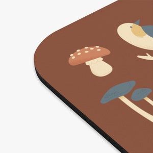 May include: A brown background with a white bird, a red and white mushroom, and two blue and white mushrooms.