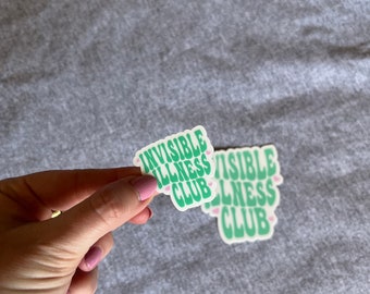 May include: Two green and white stickers with the text "Invisible Illness Club" in a retro font. The stickers have pink hearts around the text.