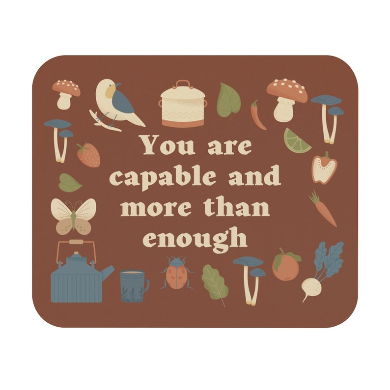 May include: A brown background with the text "You are capable and more than enough" in a retro font. The text is surrounded by various illustrations of mushrooms, a bird, a teapot, a ladybug, a carrot, a tomato, a turnip, a lemon, a bell pepper, a strawberry, and leaves.