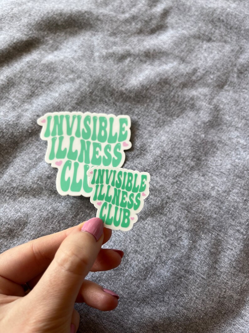 May include: Two green and white stickers with the text "Invisible Illness Club" in a retro font. The stickers have pink hearts around the text.