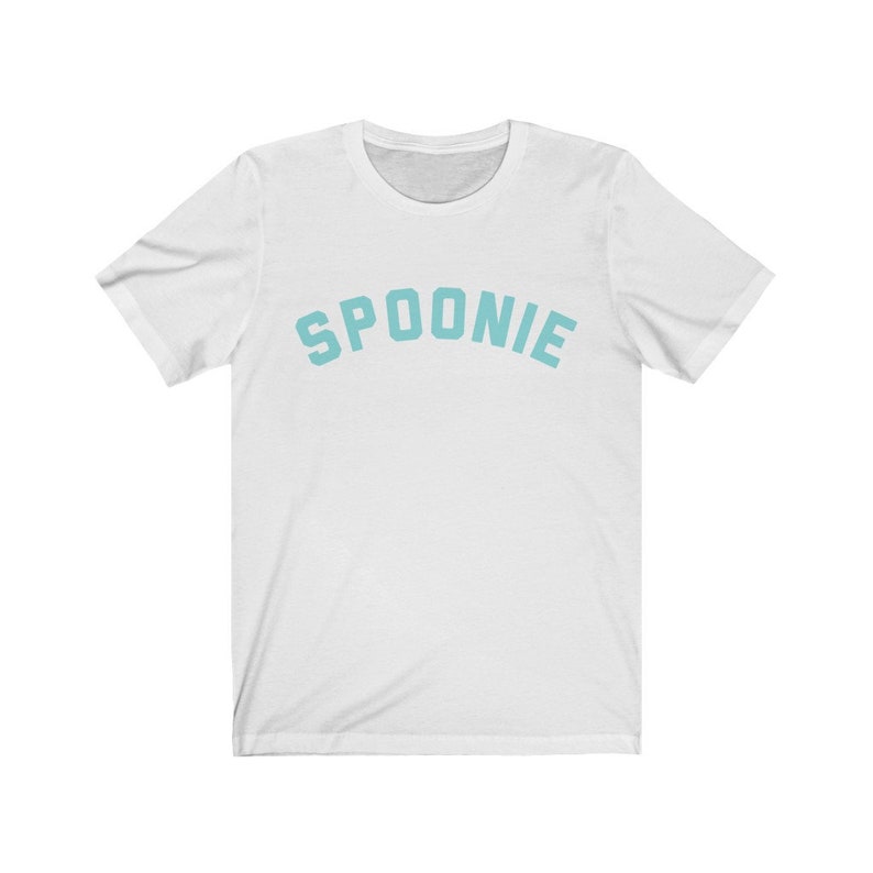 May include: White t-shirt with the word "SPOONIE" printed in a light blue color in an arched font.