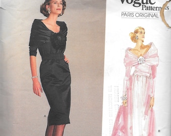 May include: A vintage Vogue sewing pattern featuring two dress designs. The first design is a black dress with a long sleeve and a high neckline. The second design is a pink dress with a long sleeve and a low neckline. The pattern is labeled "Yves Saint Laurent" and "Vogue Patterns Paris Original". The sewing rating is "Average/Moins Facile" and the pattern date is 1996.
