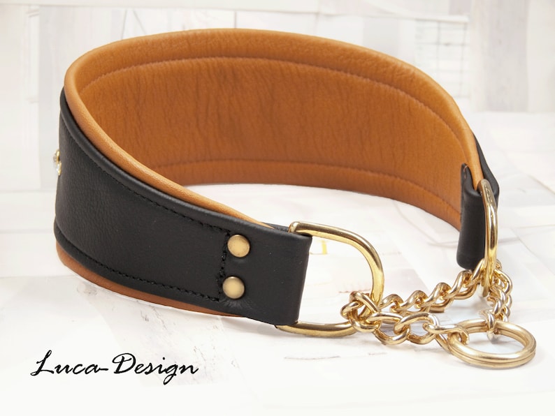 May include: Black leather dog collar with a brown leather lining and a gold chain. The collar has a gold buckle and a gold ring.