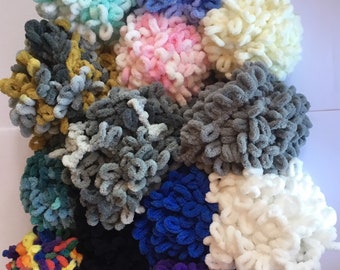 May include: A collection of 14 colorful yarn balls, each with a unique texture and color. The yarn balls are arranged in a circle, with the colors ranging from light blue to dark purple.