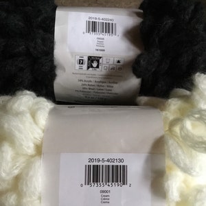 Puede incluir: Dos ovillos de hilo, uno negro y otro crema. Las etiquetas incluyen los c&oacute;digos de producto 2019-5-402240 y 2019-5-402130, los nombres de los hilos "Pepper" y "Cream", y los n&uacute;meros de producto correspondientes 09006 y 09001.