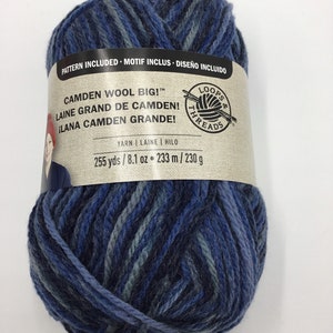May include: A ball of blue, grey, and white yarn with a label that reads "Camden Wool Big!"  "Laine Grand de Camden!"  "¡Lana Camden Grande!"  "Loops & Threads"  "Yarn | Laine | Hilo"  "255 yds / 8.1 oz = 233 m / 230 g"