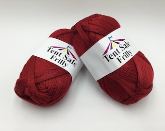 May include: Two balls of red yarn with white labels that say "Tent Sale Frilly".