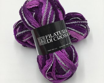 May include: Two skeins of purple yarn with silver glitter thread. The yarn is labeled "Filatura Di Crosa" and "Vimar 1991 s.a.s."