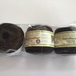 May include: Three brown balls of Bernat Handicrafter crochet thread in a clear plastic bag. The label reads "Bernat Handicrafter Crochet Thread" and "Fil de crochet".