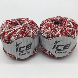 May include: Two skeins of red and white yarn with a silver label that reads "Ice Yarns" with a star.