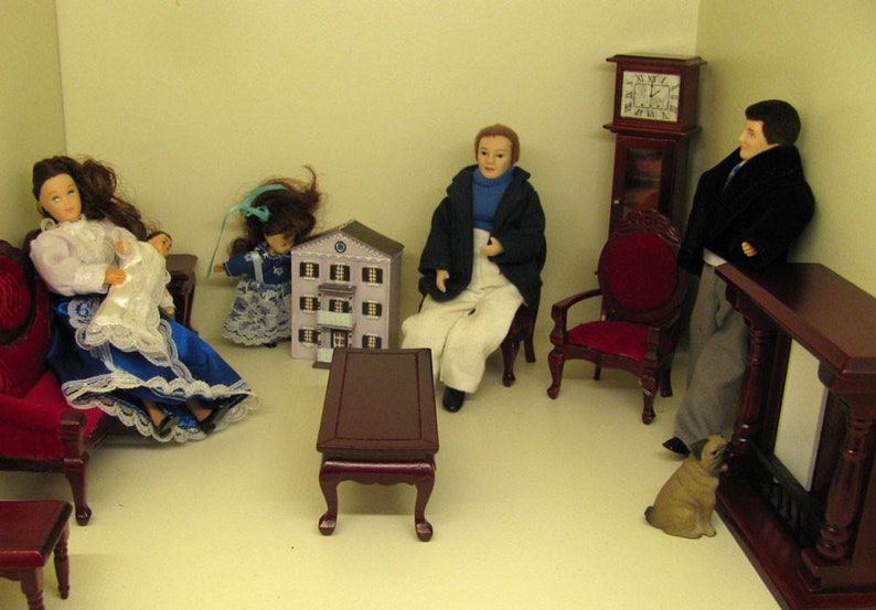 Puede incluir: Un conjunto de sala de estar de casa de mu&ntilde;ecas con una familia de mu&ntilde;ecas, muebles y un perro. Los muebles est&aacute;n hechos de madera y pintados de color marr&oacute;n oscuro. La familia de mu&ntilde;ecas est&aacute; vestida con ropa vintage. El perro es un carlino marr&oacute;n y blanco.