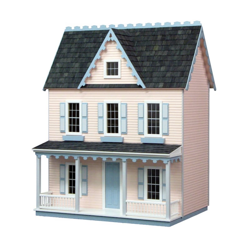 Finished 1-inch scale Vermont Farmhouse Jr. Dollhouse Kit by Real Good Toys. Front view, painted pink with blue trim. Milled MDF exterior, front porch, wooden roof shingles, shutters, window boxes. 29.4 in. tall x 24.25 wide. Kit sold unfinished.