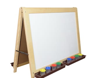 May include: A wooden easel with a white dry-erase board and a brown tray for paint cups. The tray has six colorful paint cups.
