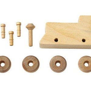 May include: Wooden train engine kit with four wheels, a chimney, and five wooden dowels. The engine is unfinished and ready to be painted.