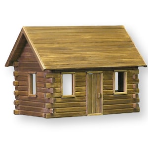 Finished 1-inch scale Crocketts Log Cabin Dollhouse Kit by Real Good Toys. Front view of rustic log cabin dollhouse made with log siding. Size 13.5 inches tall x 18 wide. Kit sold unfinished.