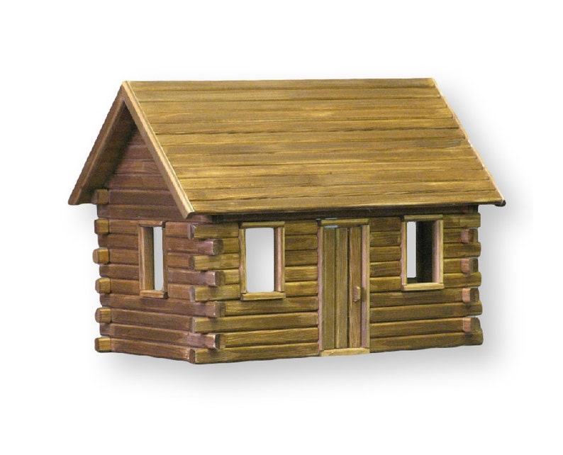 Finished 1-inch scale Crocketts Log Cabin Dollhouse Kit by Real Good Toys. Front view of rustic log cabin dollhouse made with log siding. Size 13.5 inches tall x 18 wide. Kit sold unfinished.