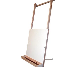 May include: A wooden easel with a white canvas panel and a built-in tray. The easel is adjustable and can be used for painting or drawing.