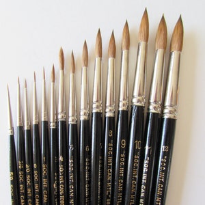 May include: A set of 13 paint brushes with black handles and gold lettering. The brushes are labeled with sizes ranging from 0 to 12 and the text "SOC. INT. CAN. MTL." and "88 PURE SABLE" or "88 red sable".