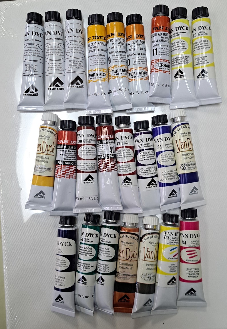 Peut inclure: Une collection de 18 tubes de peinture &agrave; l'huile Van Dyck, dispos&eacute;s en trois rang&eacute;es. Les tubes sont &eacute;tiquet&eacute;s avec le nom de la couleur, le num&eacute;ro et la marque. Les couleurs comprennent le blanc, le jaune, le rouge, l'orange, le brun, le bleu, le vert et le noir.