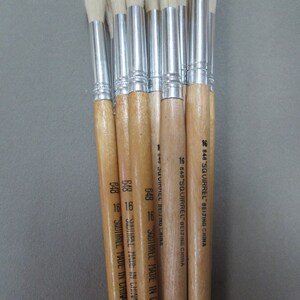 May include: A set of ten paint brushes with wooden handles and silver ferrules. The brushes have white bristles and are labeled "648 SQUIRREL" and "MADE IN CHINA".