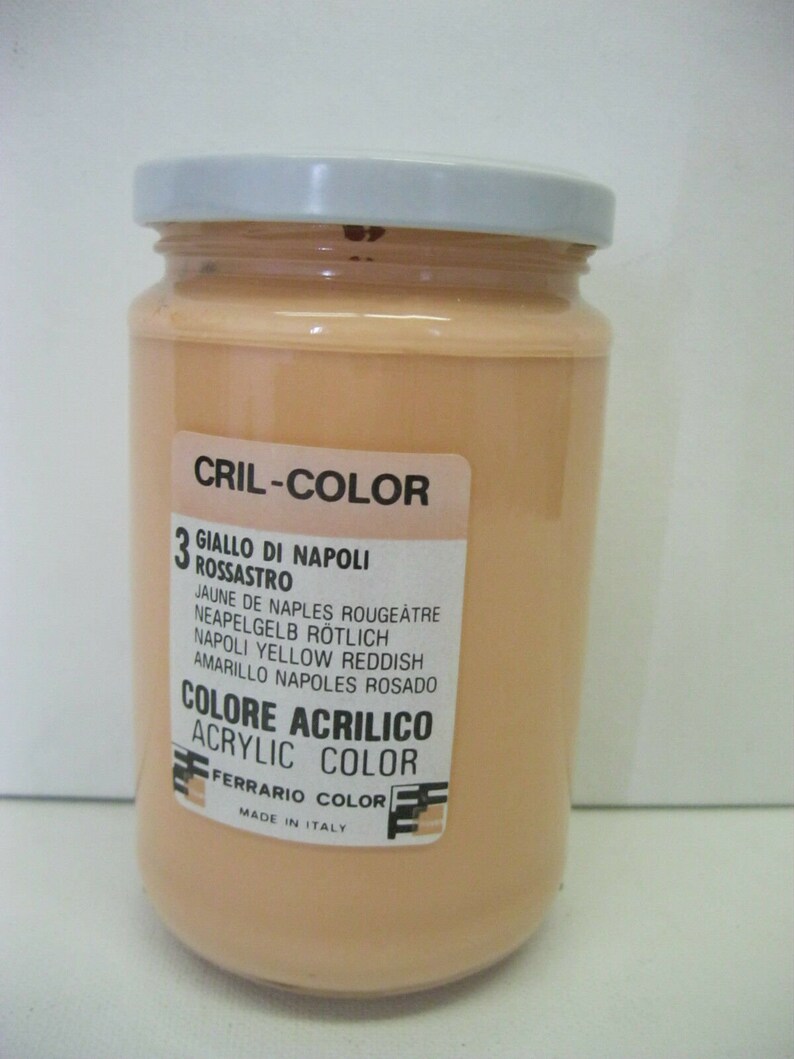 May include: A glass jar of acrylic paint labeled "CRIL-COLOR 3 GIALLO DI NAPOLI ROSSASTRO" in Italian. The paint is a light orange color. The label also includes the color name in English, French, German, and Spanish. The label says "ACRYLIC COLOR" and "FERRARIO COLOR" and "MADE IN ITALY".