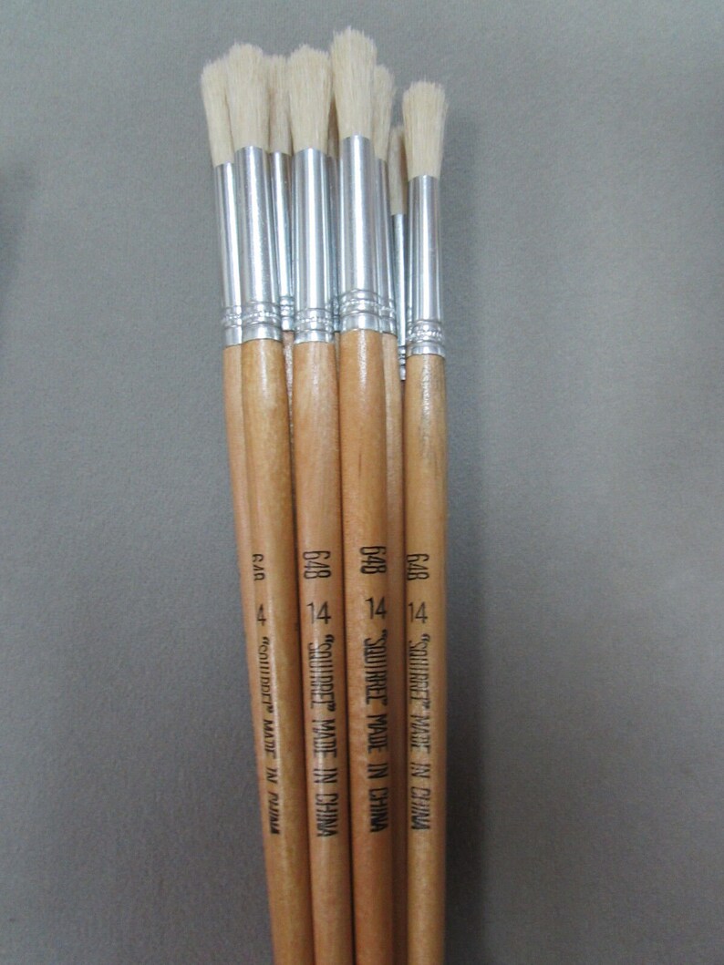 May include: A set of eight paint brushes with wooden handles and white bristles. The handles are labeled "SQUIRREL MADE IN CHINA" and "648 14".