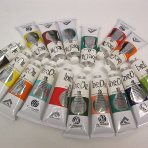 May include: A collection of 18 tubes of water-based oil paint in various colors, arranged in a semi-circle. The tubes are labeled "idro-oil" and "ferrario".