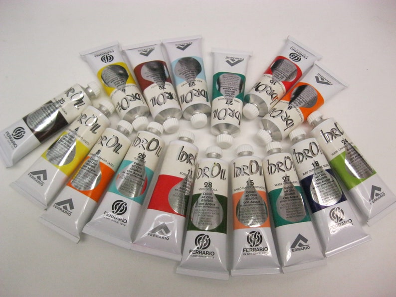 May include: A collection of 18 tubes of water-based oil paint in various colors, arranged in a semi-circle. The tubes are labeled "idro-oil" and "ferrario".