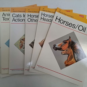 May include: A stack of art instruction books with white covers and orange accents. Titles include "Horses/Oil," "Horses Heads," and "Cats in Action." The cover art features animal illustrations, including a tiger and horses.