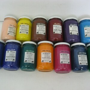 May include: A collection of 12 acrylic paint jars in various colors, including blue, green, red, yellow, orange, and brown. Each jar has a white label with the brand name "CRIL-COLOR" and a number.