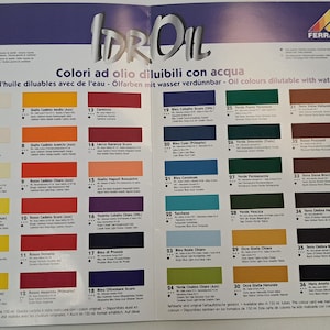 May include: A color chart for water-soluble oil paints. The chart shows 36 different colors, each with a number and a name in Italian. The chart is printed on a white background with blue and red borders.