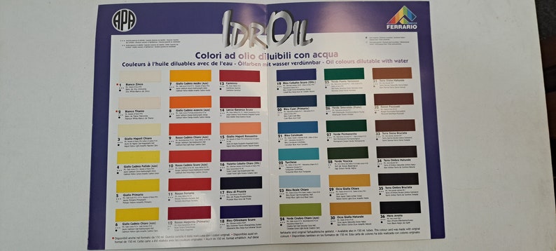 May include: A color chart for water-soluble oil paints. The chart shows 36 different colors, each with a number and a name in Italian. The chart is printed on a white background with blue and red borders.