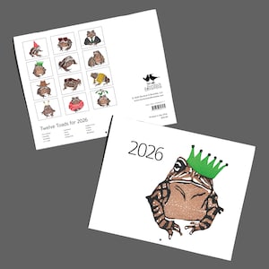May include: A calendar titled "Twelve Toads for 2026" featuring illustrated toads in various outfits. The calendar shows a toad wearing a green crown. The back of the calendar has the text "Printed in the USA".