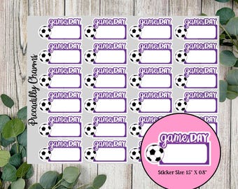 May include: Sheet of gray stickers with a soccer ball and the words "game DAY" in purple. Each sticker has a white rectangular space for writing. A pink circle shows a close-up of a sticker, with the size 15" x 0.8".