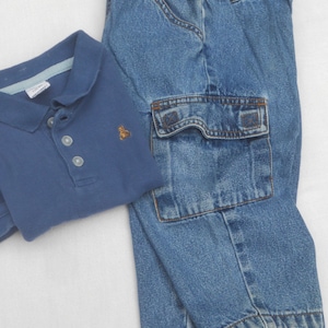 May include: A blue short-sleeved polo shirt with a small embroidered bear logo and three buttons, paired with blue denim cargo pants featuring an elastic waistband and large side pockets with flaps and visible stitching details.
