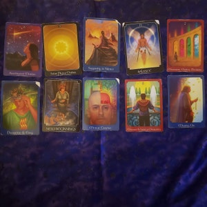 Puede incluir: Un juego de diez cartas de tarot con ilustraciones coloridas y texto. Las cartas están dispuestas en dos filas de cinco. Las cartas presentan imágenes de una mujer en un bosque, un hombre con alas, una mujer con una espada, un hombre con una corona, una mujer con un bastón, un hombre con un libro, un hombre con un corazón, un hombre con una fuente, un hombre con una puerta y un hombre con un bastón.