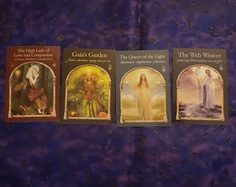 Op de afbeelding: Vier tarotkaarten met illustraties van feeën en vrouwen. De kaarten zijn getiteld "The High Lady of Love and Compassion", "Gaia's Garden", "The Queen of the Light", en "The Web Weaver".