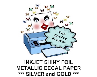 May include: An illustration of a blue inkjet printer with a cartoon face and butterflies. The text reads "INKJET SHINY FOIL METALLIC DECAL PAPER *** SILVER and GOLD ***" and "The Crafty Printer".