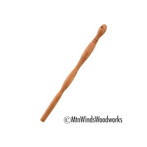 May include: A wooden knitting needle with a smooth, rounded tip and a slightly curved handle. The needle is made of light brown wood and is approximately 12 inches long.