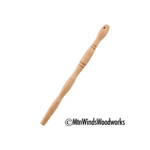 May include: A wooden dowel rod with a rounded end and a small hole drilled through the top. The rod is smooth and has a natural wood finish.